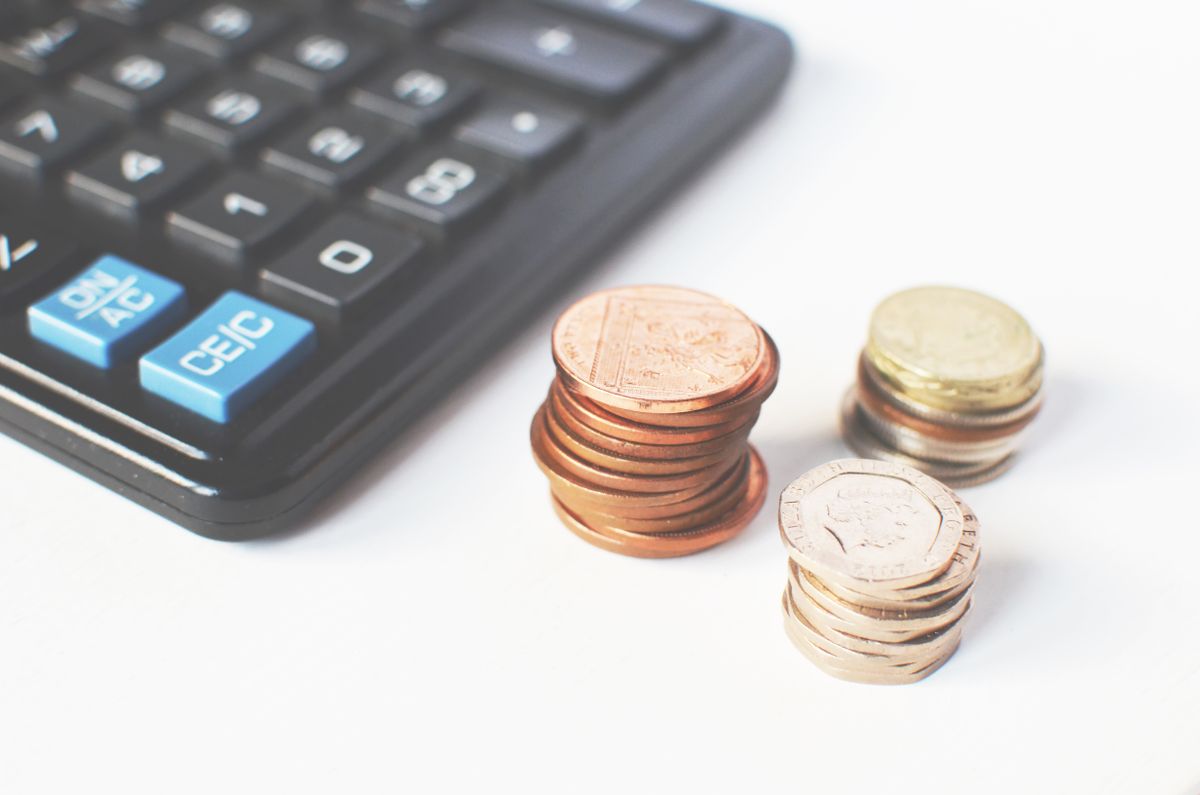 Coins and a calculator illustrating product profit and margin analysis for ecommerce
