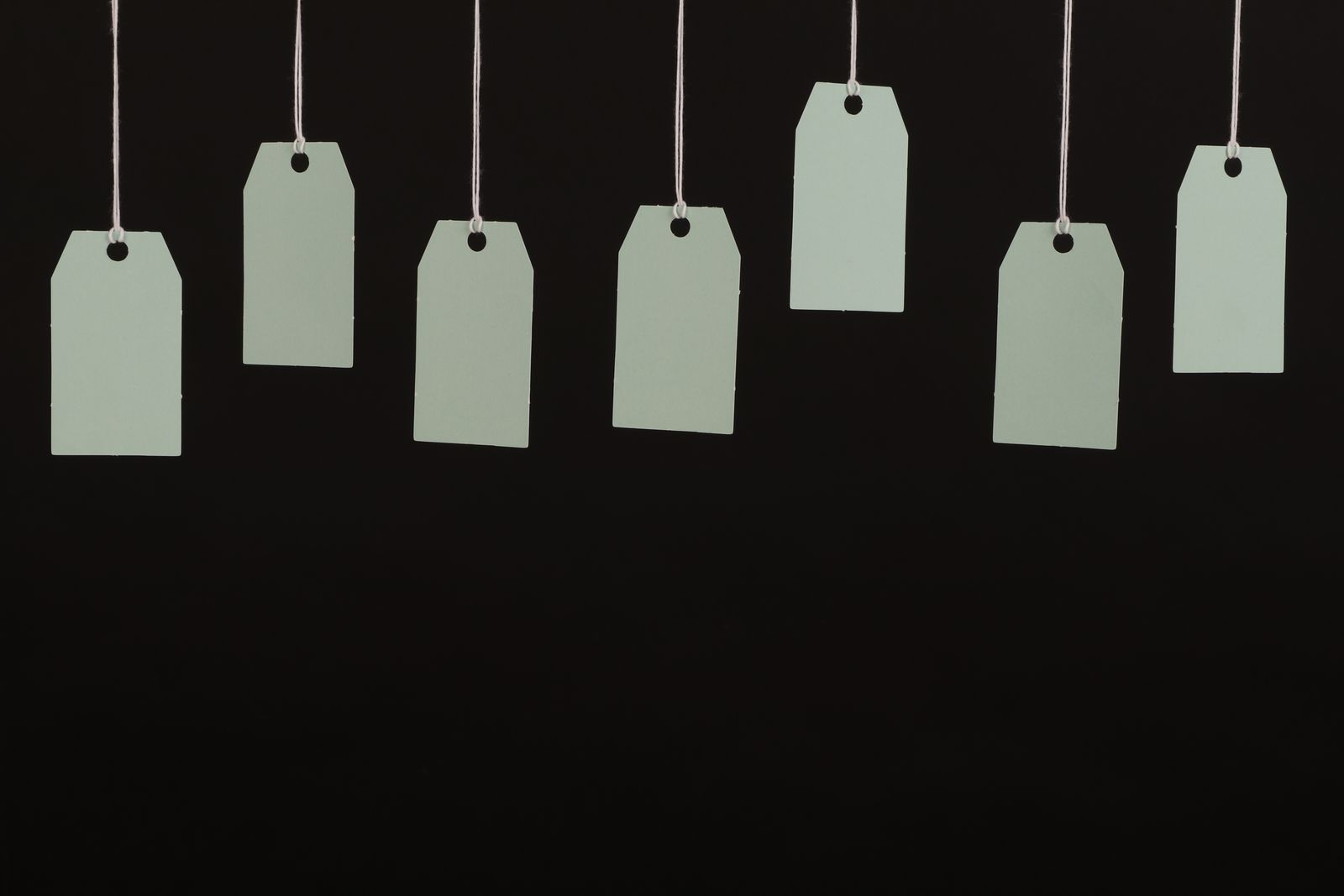 Blank tags hanging on strings against a dark background